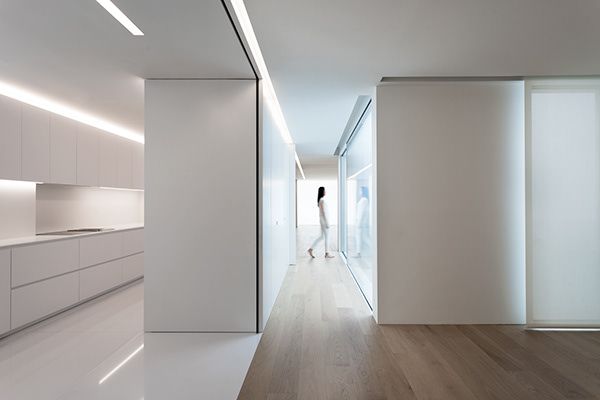 an empty room with white walls and wood flooring is lit by recessed lighting