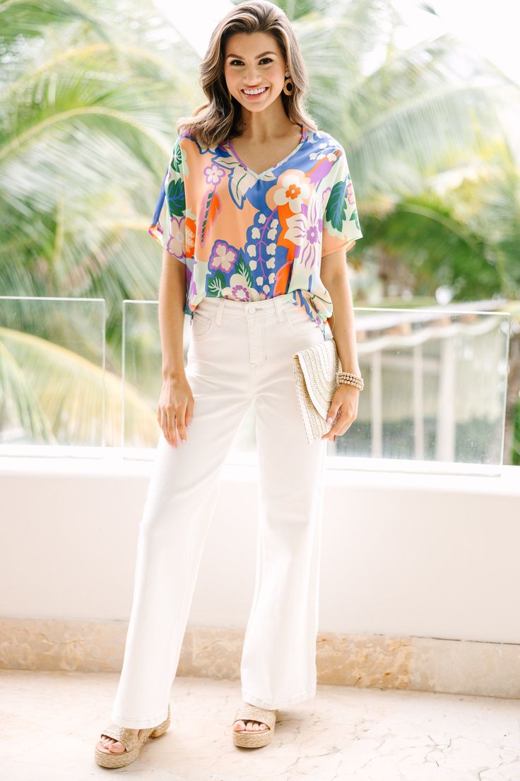 This top is so cute and comfy! That print is so pretty and those colors are so fun. This light blouse is going to look great with white jeans or shorts this spring and summer! V-neckline Short sleeves Floral print No stretch Savannah is wearing the small. Casual Floral Print V-neck Top For Summer, Chic White V-neck Top For Day Out, Casual Short Sleeve V-neck Top For Brunch, Summer Rayon V-neck Tops, Summer V-neck Blouse With Tropical Print, Vibrant Print V-neck Top For Brunch, Trendy V-neck Blouse With Vibrant Print, Summer Cotton V-neck Top For Day Out, Spring V-neck Printed Tops