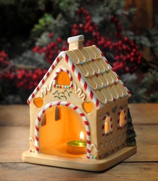 a small gingerbread house candle holder on a table