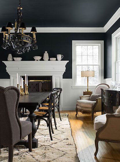 the dining room is decorated in black and white with an antique chandelier hanging from the ceiling