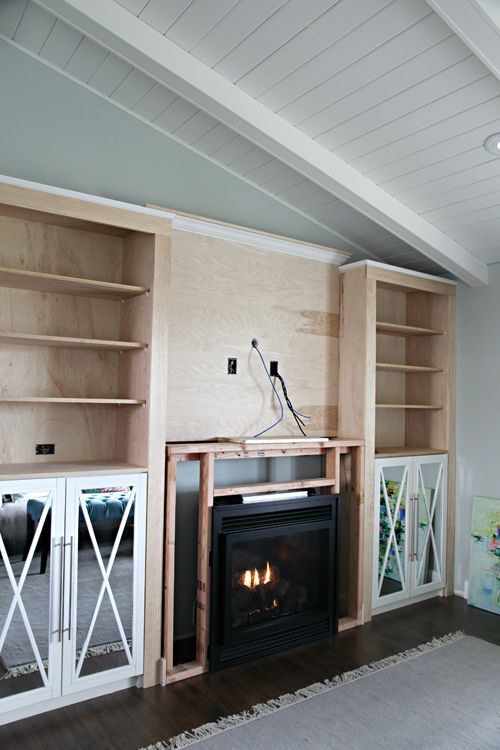 a living room with built in bookshelves and a fireplace