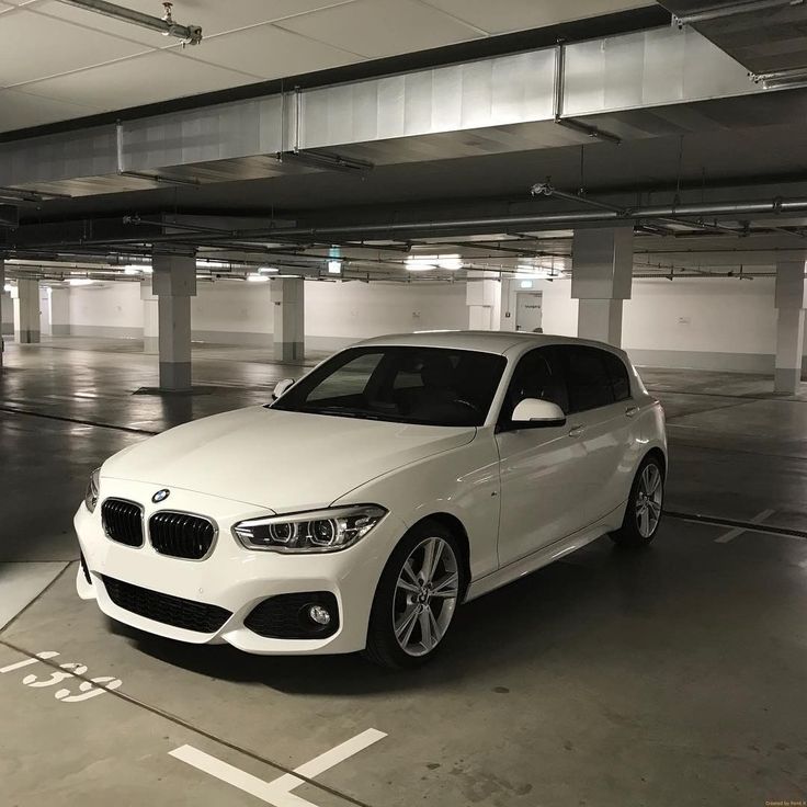 a white car is parked in an empty parking garage with lots of space to put it's lights on