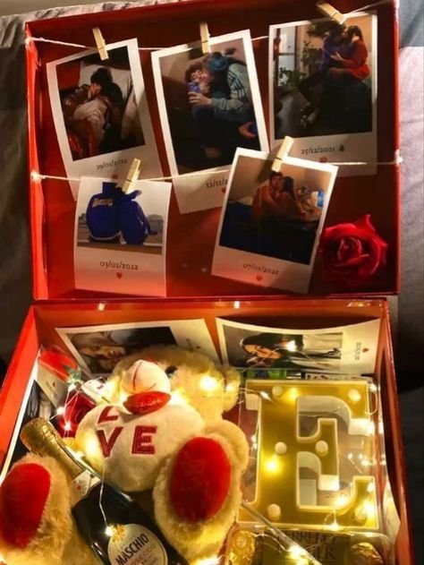 a teddy bear sitting inside of a red box with photos on it's side