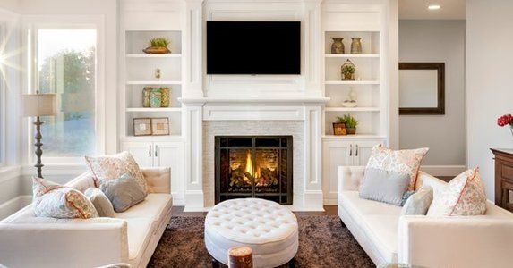 a living room filled with furniture and a fire place in front of a flat screen tv