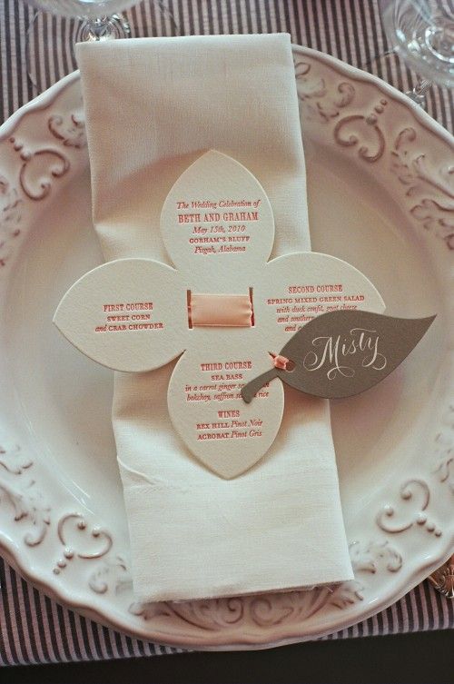 a white plate topped with paper napkins and place settings