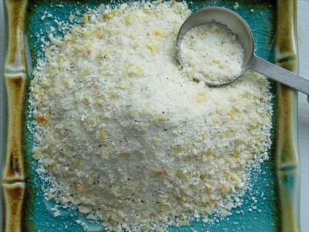 a blue plate topped with lots of white food next to a metal measuring cup on top of it