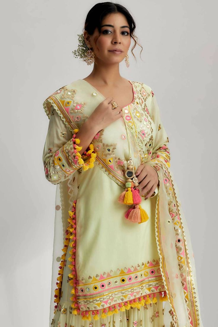 The friya short kurta sharara set with mirror work, pompoms, tassels and intricate hand and machine embroidery is a true masterpiece that celebrates artistry and craftsmanship. It is the perfect choice for festive occasions, weddings, or any special event where you want to make a lasting impression. Mirror Work Embroidery, Kurta Sharara Set, Kurta Sharara, Short Kurta, Desi Clothes, Sharara Set, Punjabi Suits, Mirror Work, Indian Outfits