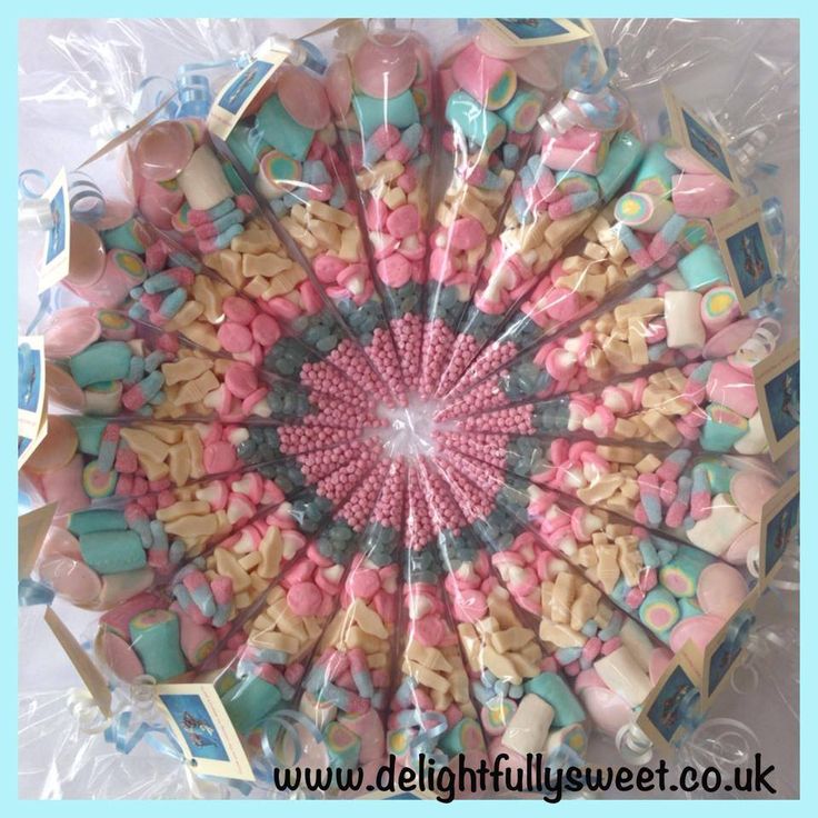 this is an aerial view of candy in the shape of a flower with pink, blue and white candies