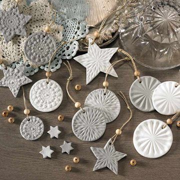 some ornaments are sitting on a table next to a glass bowl and doily with beads