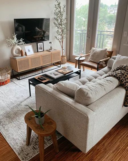 a living room filled with furniture and a flat screen tv on top of a wooden table