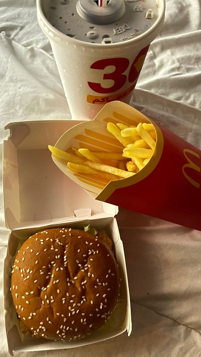 a hamburger and french fries are sitting next to a soda