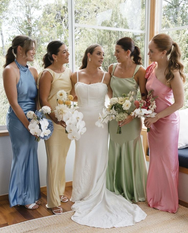 four bridesmaids standing in front of a large window