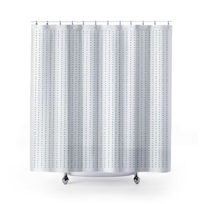 a white shower curtain with black dots on the side and wheels in front of it