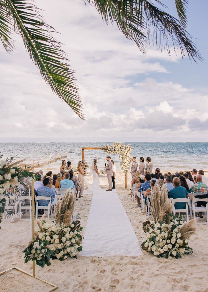 a wedding ceremony on the beach with palm trees