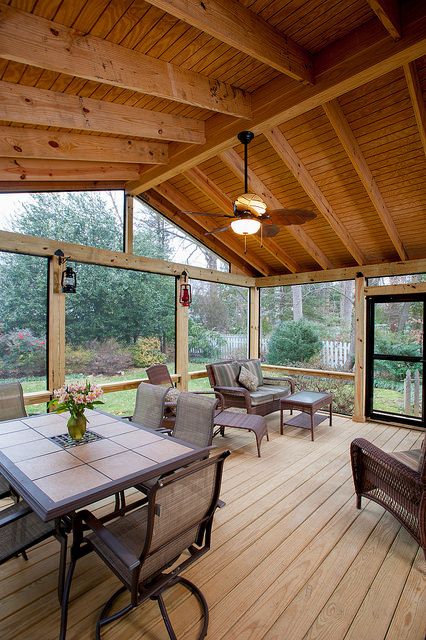 a covered porch with couches and chairs