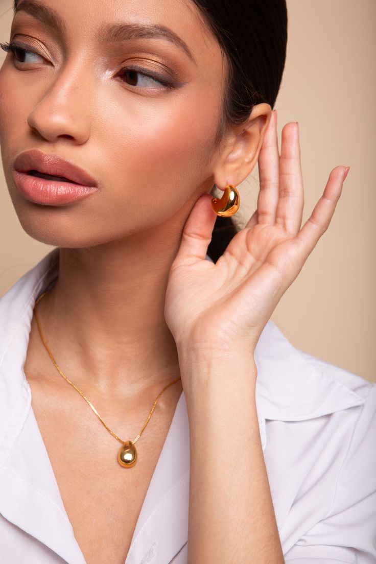 Ignite your style with the enchanting Jora Necklace. Plated in 18k gold, this captivating accessory adds a touch of luxury to any ensemble. Its tear-shaped pendant, measuring 28mm (h) by 16mm (w), exudes elegance. Crafted from nickel-free and lead-free brass, it ensures comfort and compatibility with sensitive skin. With a length of 18 inches plus a 2-inch extender, the Jora Necklace offers a perfect fit for every occasion. Elevate your look and leave a lasting impression with this timeless piece of beauty. Product Detail 18k gold plating Brass Size:18in+2in Pendant size: 28mm(h) 16mm(w) Nickel-Free Lead-Free Jewelry photos are enlarged to show detail. Packaging Every Ose purchase will arrive in a box . In that box our pieces are placed in our microfiber pouches or white jewelry boxes. All Timeless Teardrop Drop Necklace For Formal Occasions, Modern Gold Teardrop Drop Earrings, Modern Gold Plated Oval Pendant Necklace, Timeless Teardrop Pendant Drop Necklace For Formal Occasions, Elegant Teardrop Pendant Drop Necklace, Modern Gold Jewelry With Pearl Drop, Elegant Necklace With Detachable Teardrop Pendant, Elegant Gold-tone Necklace With Pearl Drop, Formal Gold-plated Jewelry With Pearl Pendant