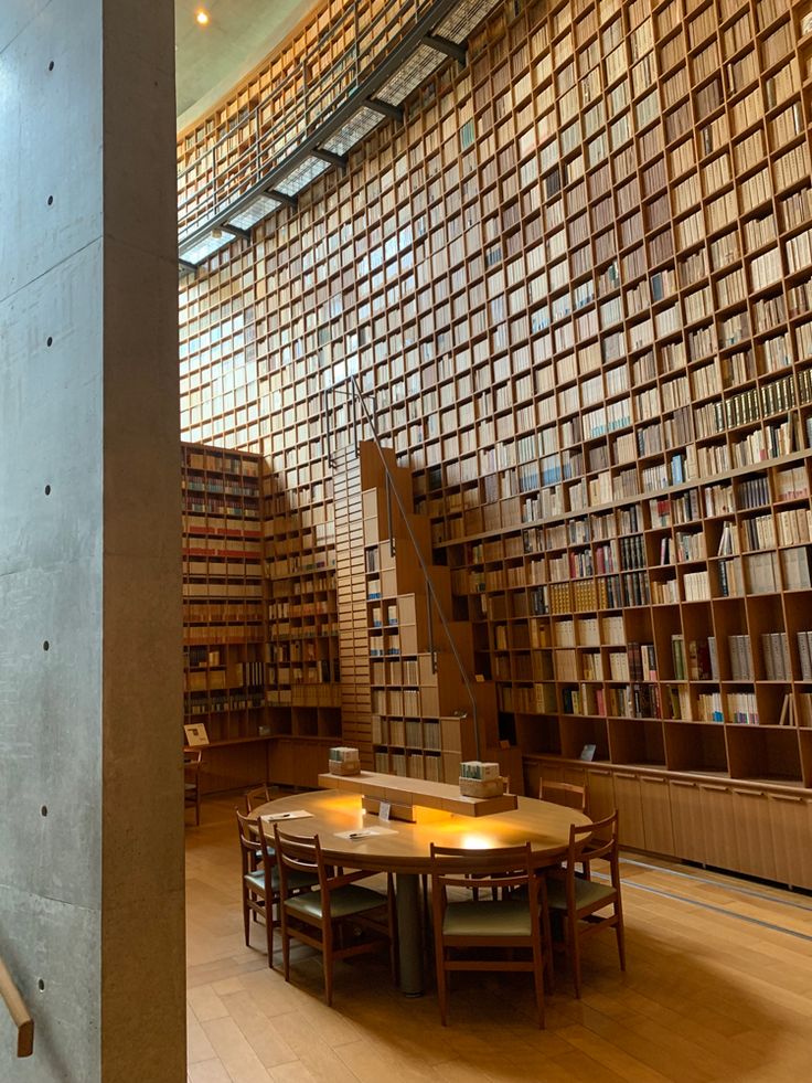 the interior of a library with many bookshelves and tables in front of them