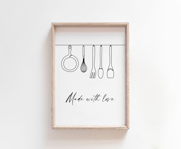 a framed poster with kitchen utensils hanging on the wall above it that says make with love