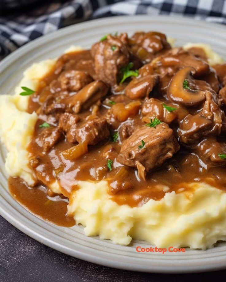 a white plate topped with mashed potatoes covered in gravy