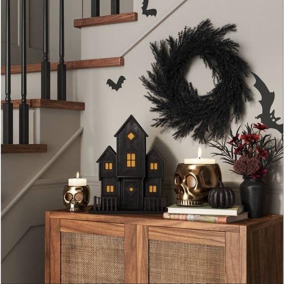 a halloween scene with candles and decorations on a table in front of a staircase case