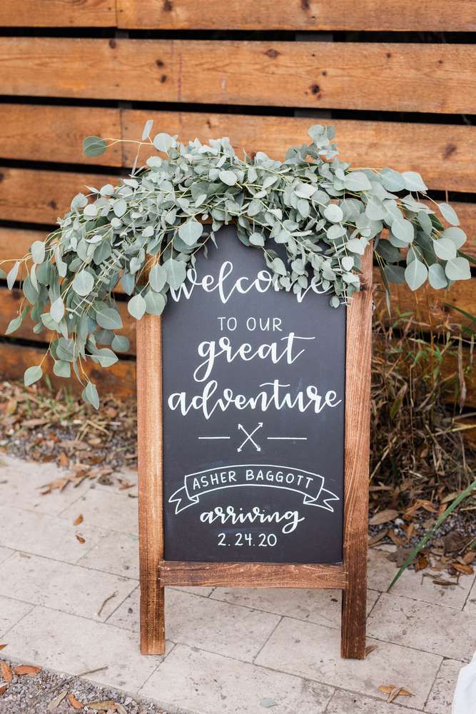 a chalkboard sign that says welcome to our great adventure with greenery on it