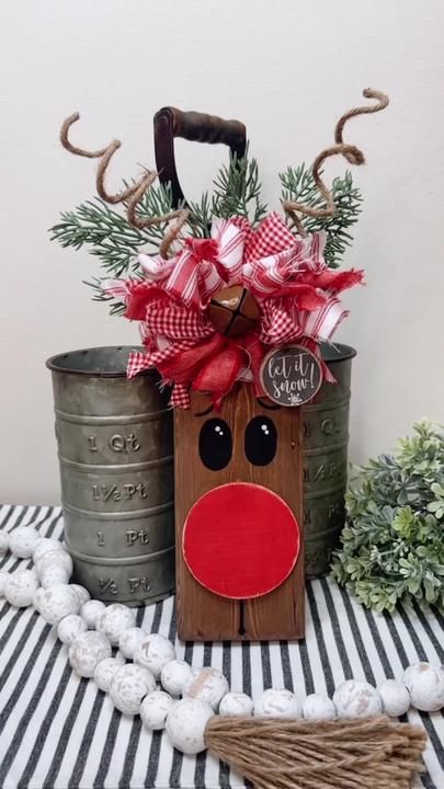 a wooden reindeer head sitting next to two metal pails