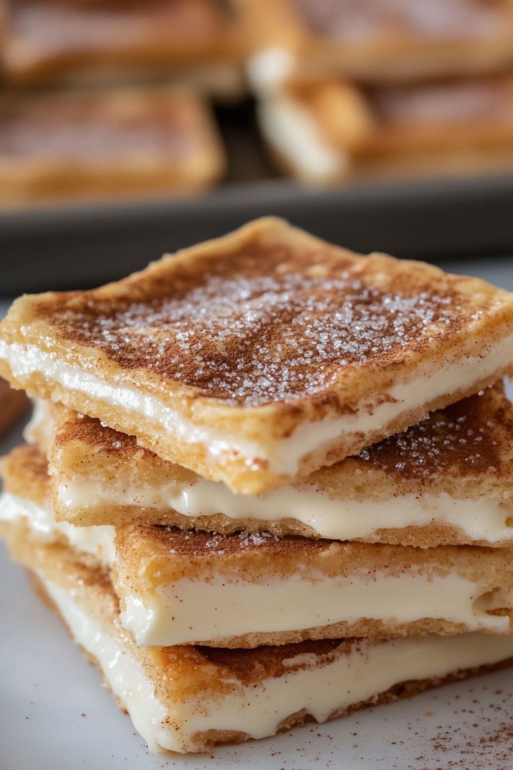 four pieces of french toast stacked on top of each other with powdered sugar all over them