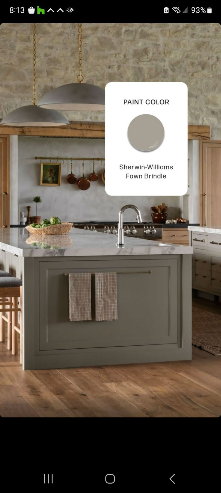 a kitchen with an island in the middle and cabinets on both sides, along with a sign that says paint color