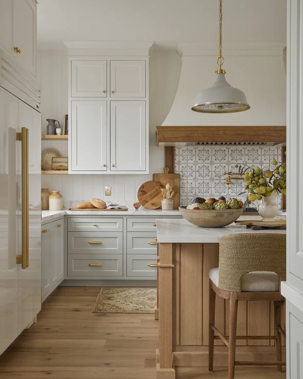 the kitchen is clean and ready for us to use it's white cabinets, wood floors, and counter tops