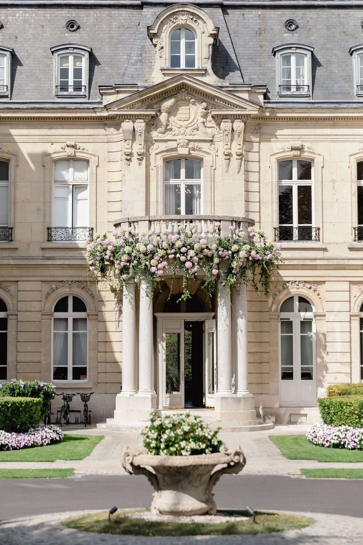 a large building with many windows and flowers on the front