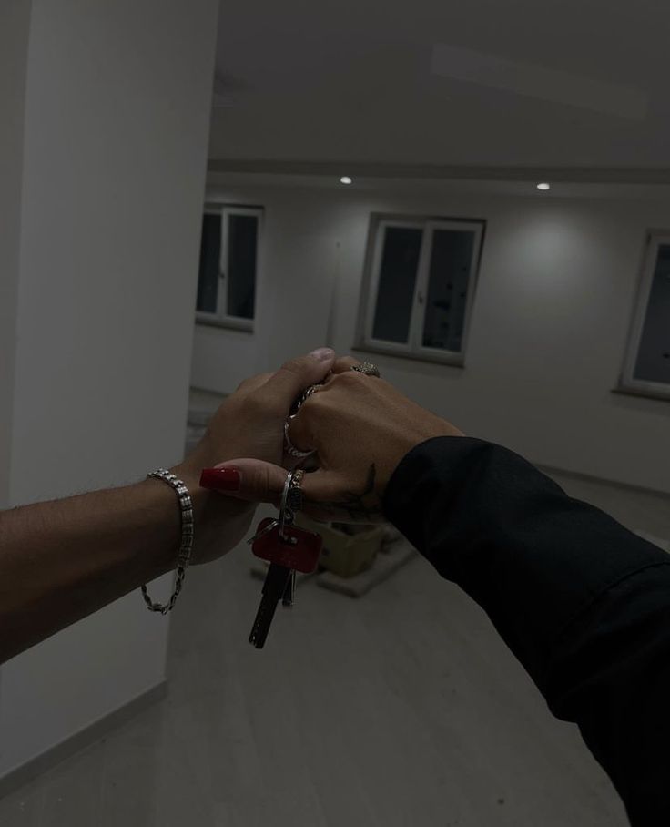 two people holding hands with keys in each other's hand, while another person holds the key to their new home