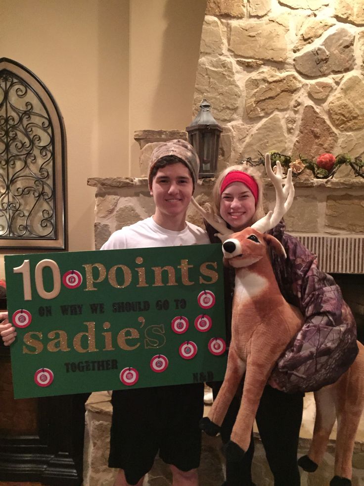 two people standing next to each other holding a sign