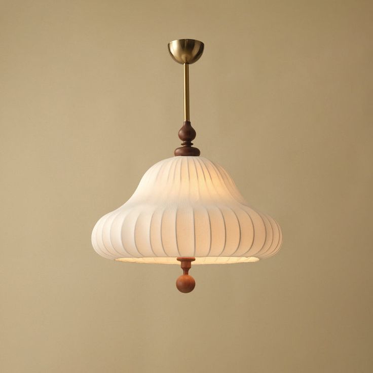 a white lamp hanging from a ceiling in a room with beige walls and flooring