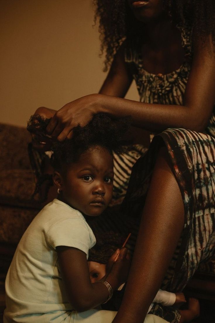 a woman combing a young child's hair