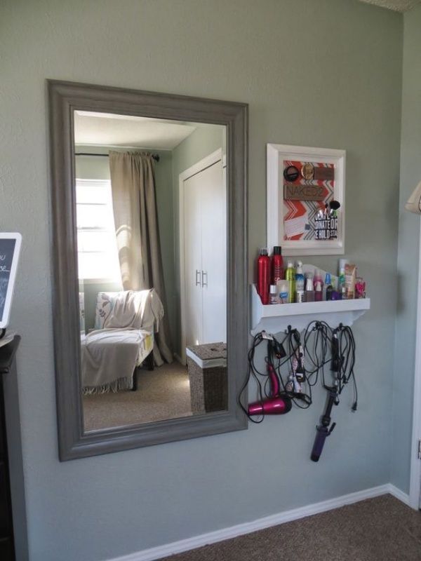 a room with a mirror, hair dryer and other items hanging on the wall