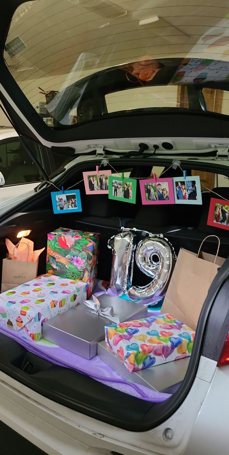 the trunk of a car is filled with presents and gifts for someone to put in it