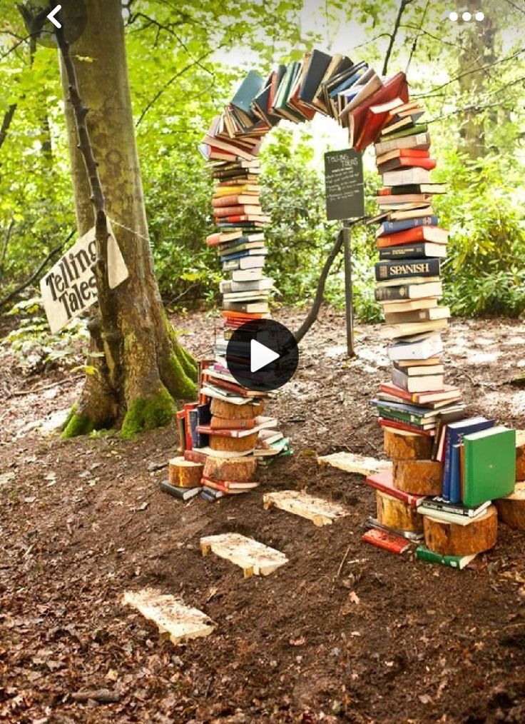 an arch made out of books in the woods