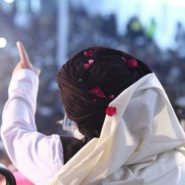 a woman in a white robe is holding her hand up to the side and pointing at something