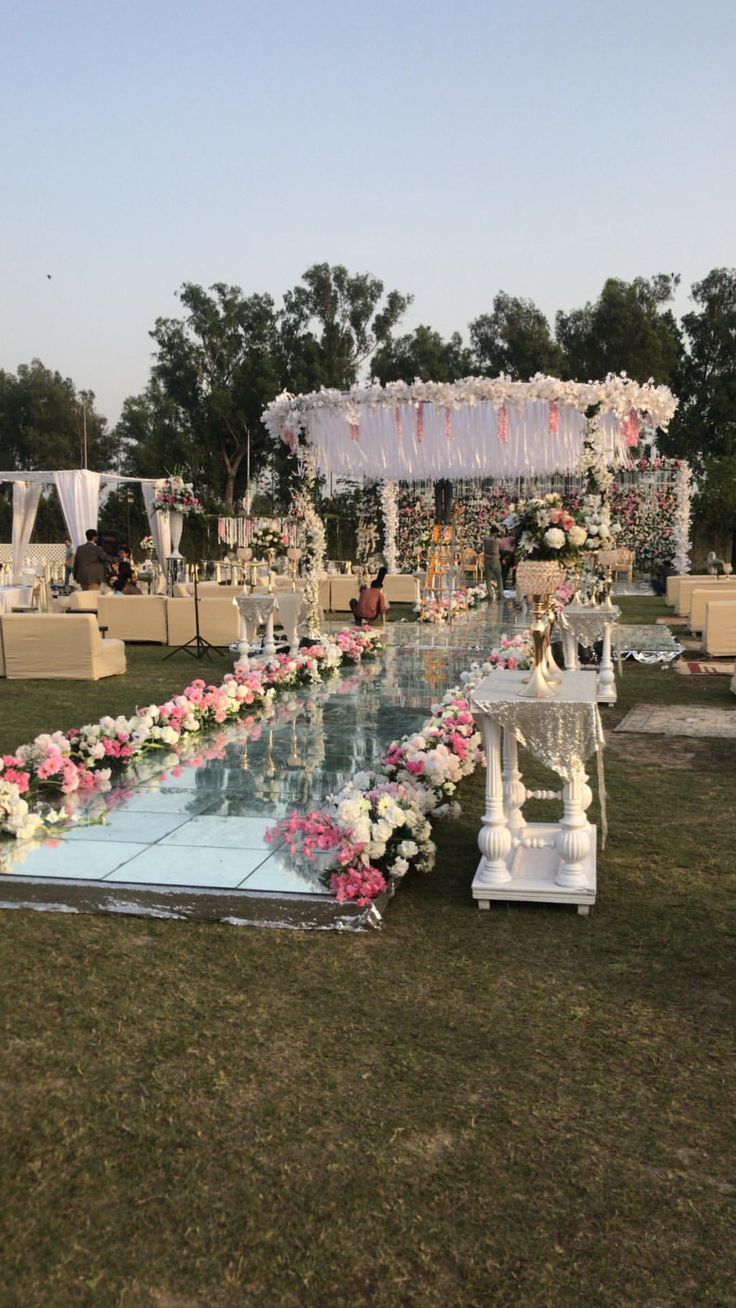 an outdoor wedding setup with flowers and candles