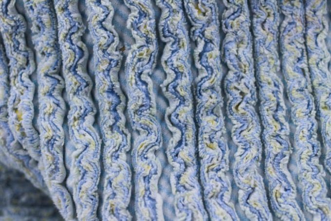 an up close view of a blue and white blanket with wavy lines on it's edges