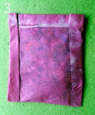 a piece of pink tissue paper sitting on top of a green surface