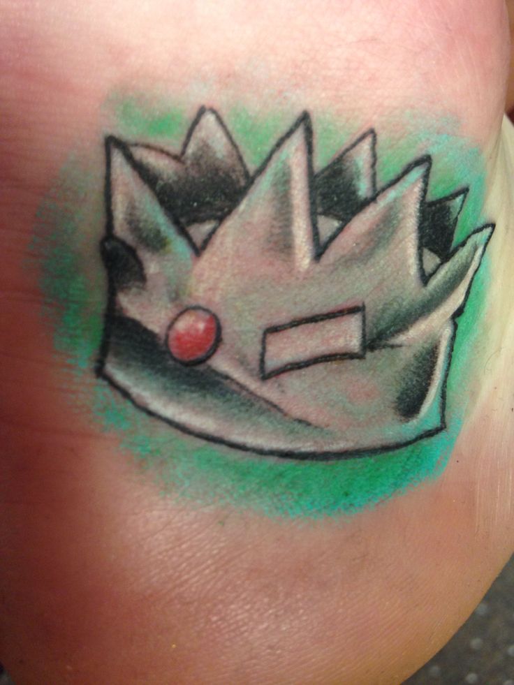 a person with a tattoo on their leg that has a drawing of a crown on it