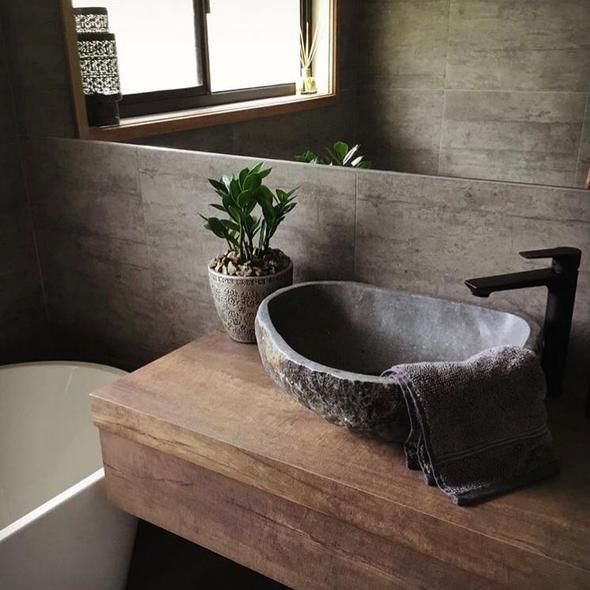 a bathroom with a sink, toilet and tub next to a plant in a pot