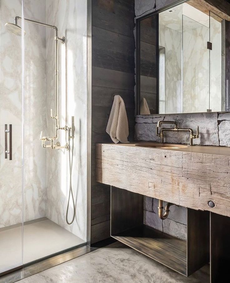 a bathroom with a sink, mirror and shower in it's corner area next to a walk - in shower