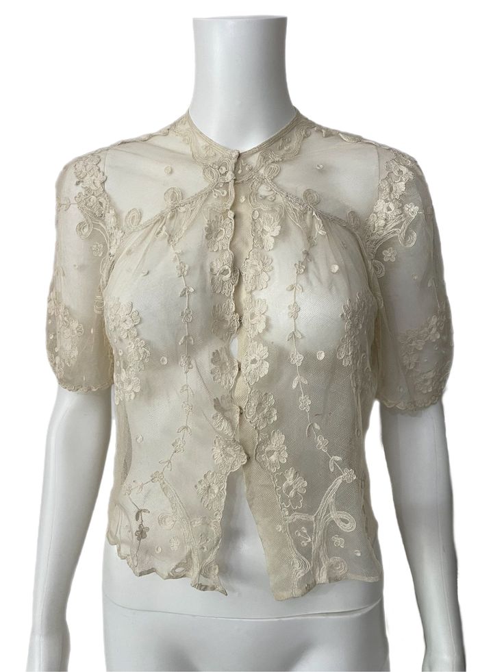 "This is a very pretty 1930's lace blouse. It has small puffed sleeves and popper closures on the front.  The piece is in very good condition. There are some small holes on the back top neckline, one under the one sleeve and a few scattered on the front of the piece. There is a small repair on the floral edge near the poppers. It's a beautiful and versatile piece. Size small best fit U.K. 8-10 Bust approx 36\" Length from nape of neck 16\"" Formal Fitted Blouse With Scalloped Lace, Fitted Scalloped Lace Short Sleeve Blouse, Daywear Scalloped Lace Fitted Tops, Fitted Scalloped Lace Tops For Daywear, Lace Tops With Buttons For Formal Occasions, Formal Lace Tops With Buttons, Vintage Lace Blouse With Lace Top, Vintage Short Sleeve Blouse With Lace Collar, Vintage Lace Top Blouse