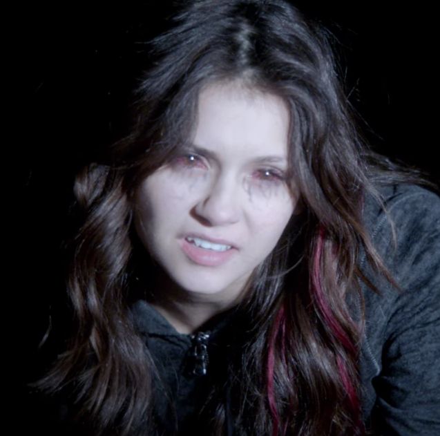 a woman with long hair is looking at the camera