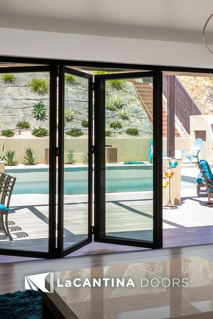 an open sliding glass door in front of a swimming pool