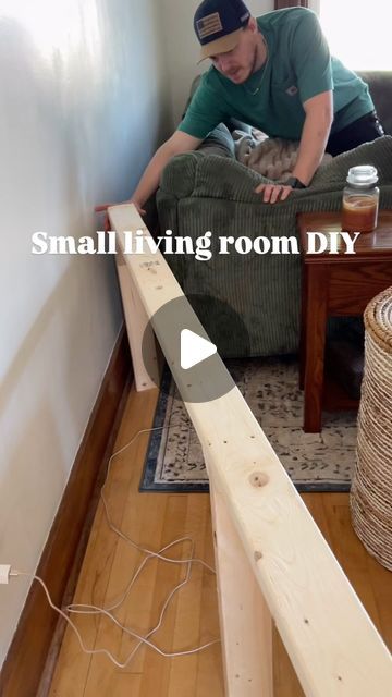 a man sitting on a couch in front of a coffee table with a wooden stick sticking out of it