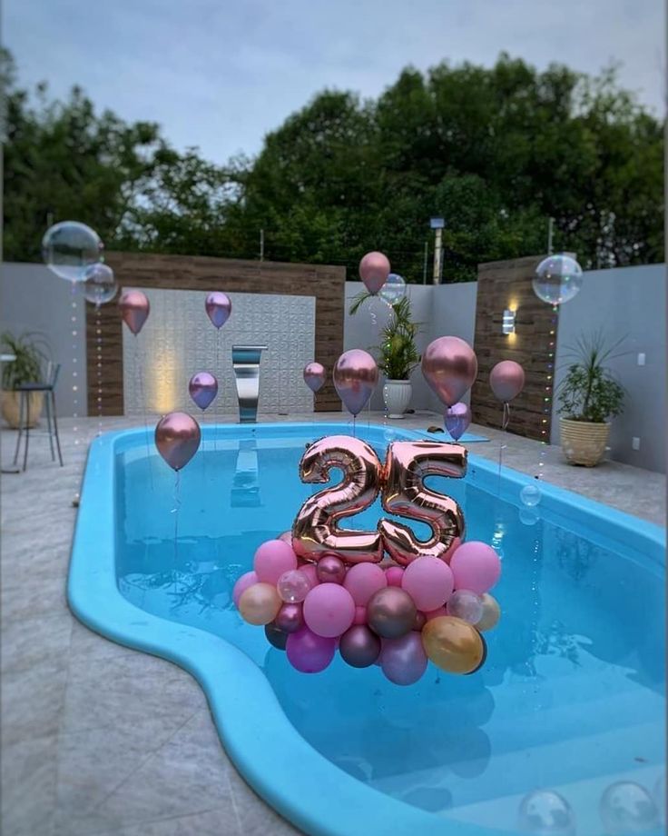 a pool with balloons floating in it and the number twenty