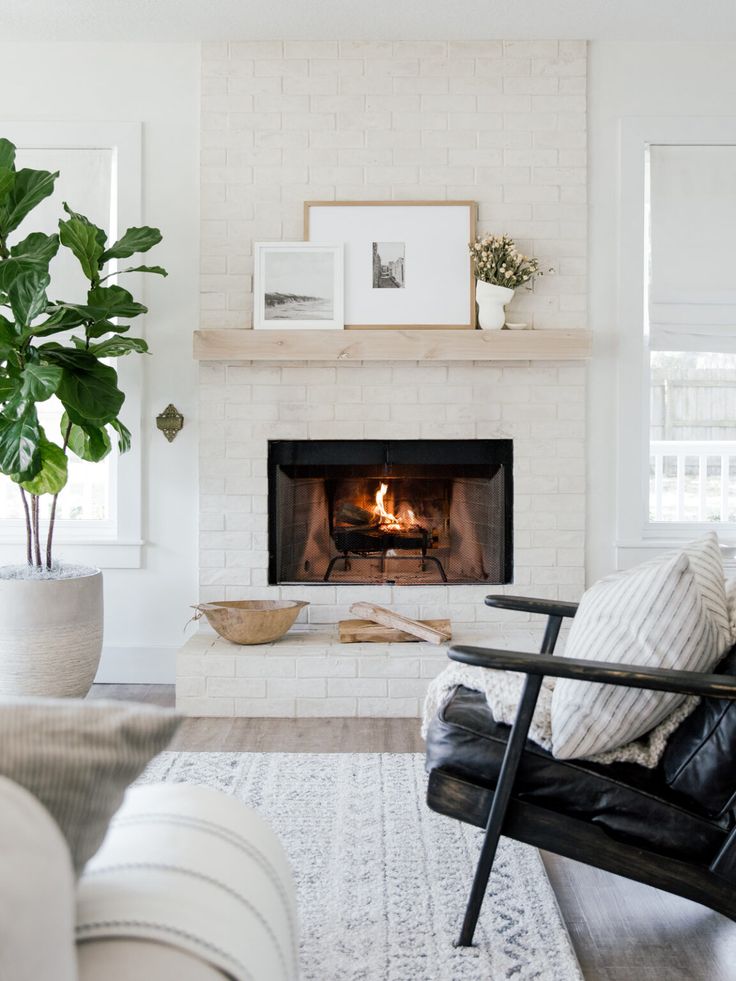 a living room with a white brick fireplace